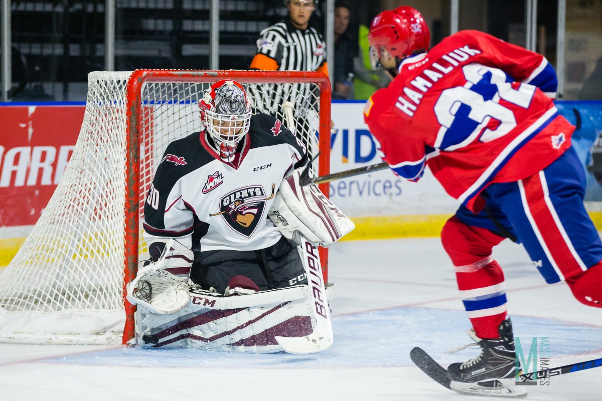 Vancouver Giants goaltender David Tendeck makes a save off of Spokane forward Taylor Ross
